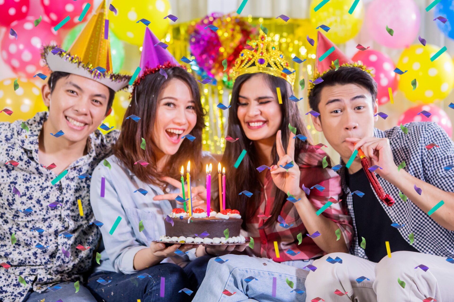 Picture of four young people celebrating birthday party while smiling at the camera at home